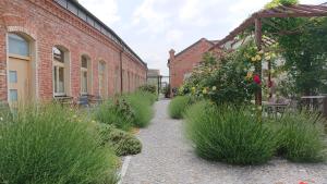 a brick building with a walkway with flowers and plants at Maison am Liesingbach in Vienna