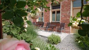 a garden with chairs and flowers in front of a building at Maison am Liesingbach in Vienna