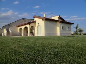 a house with a large grass field in front of it at Marinagri Resort in Policoro