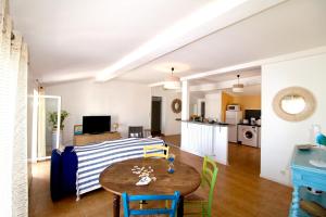 cocina y sala de estar con mesa y sillas en Grand appartement avec vue sur quai en Sète