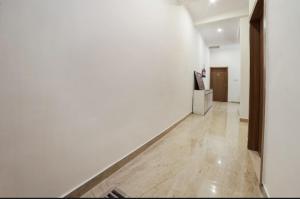 an empty hallway with white walls and a wooden floor at Hotel Arrow 19 in Bareilly