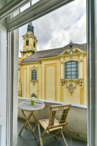 uma mesa e cadeiras numa varanda com um edifício amarelo em King of Church Budapest em Budapeste
