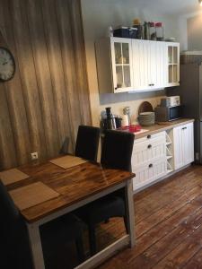 kuchnia z drewnianym stołem z krzesłami i blatem w obiekcie Schronisko Srebrny Potok apartament w mieście Lubawka