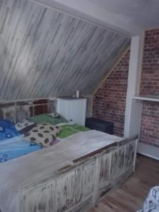łóżko w pokoju z ceglaną ścianą w obiekcie Schronisko Srebrny Potok apartament w mieście Lubawka