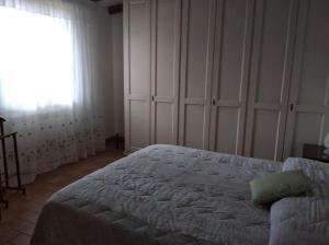 a bedroom with a large bed and a window at Agriturismo Il Selvello in Montemassi +21 photos