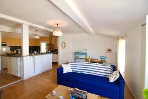 Il comprend un salon avec un canapé bleu et une cuisine. dans l'établissement Grand appartement avec vue sur quai, à Sète