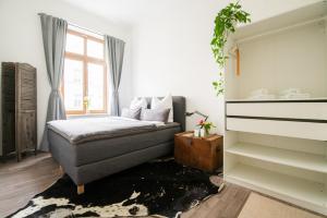 Schlafzimmer mit einem Bett und einem Fenster in der Unterkunft theleaf - design apartment & café in Leipzig