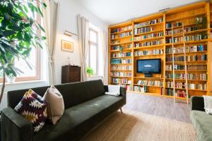 a living room with a green couch and book shelves at theleaf - design apartment & café in Leipzig