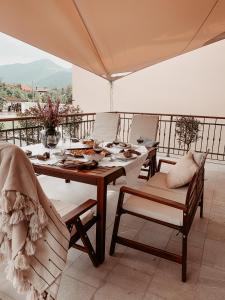 een tafel en stoelen met eten op een balkon bij Pr' Kramarju - House in the heart of Kobarid in Kobarid
