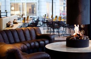 une salle avec des canapés et une cheminée dans un restaurant dans l'établissement Hotel V Frederiksplein, à Amsterdam
