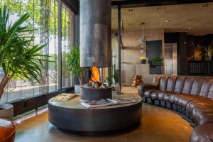 a living room with a couch and a fireplace at Hotel V Frederiksplein in Amsterdam
