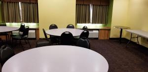 a conference room with tables and chairs and windows at Microtel Inn & Suites by Wyndham Delphos in Delphos