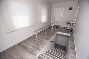 - un escalier dans une chambre blanche avec un escalier dans l'établissement Apartmani Nera De Lux, à Bela Crkva