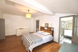 biała sypialnia z łóżkiem i oknem w obiekcie Grand appartement avec vue sur quai w mieście Sète