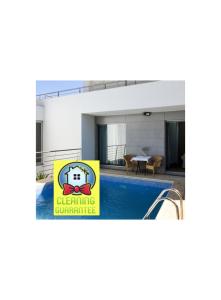 um sinal em frente a uma casa com piscina em Pé na Areia - Guest House em Vila Real de Santo António