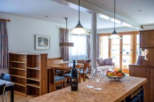 eine Küche und ein Wohnzimmer mit einem Tisch und Weingläsern in der Unterkunft Ferienwohnung Steinröschen in Flumserberg