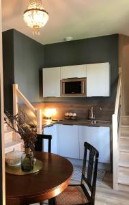 a kitchen with a wooden table and a microwave at Perlépampille in Dinan