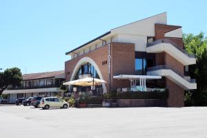 un bâtiment avec des voitures garées dans un parking dans l'établissement Hotel Ombra, à Riccione