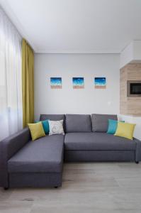 a living room with a gray couch with yellow and blue pillows at Studio Take A Break in St. St. Constantine and Helena