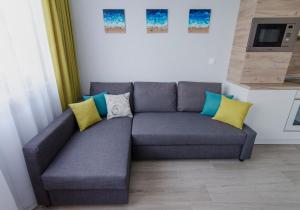 een bank in een woonkamer met gele en blauwe kussens bij Studio Take A Break in Sveti Konstantin