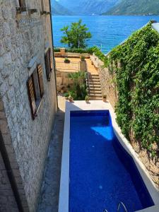 - une piscine à côté d'un bâtiment avec vue sur l'eau dans l'établissement Luxury Stone Villa, à Kotor