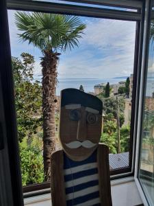 a statue in front of a window with a palm tree at Sunny apartment 150 m from the sea in Opatija