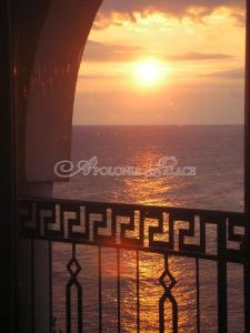 a view of the ocean from a balcony with the sunset at Apart Hotel Apolonia Palace in Sinemorets