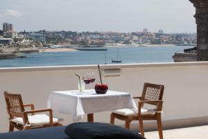 a table with wine glasses and an apple on a balcony at Villa Cascais Boutique Hotel in Cascais