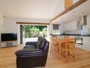 a kitchen and living room with a table and a couch at The Cart House in St Austell