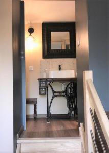 a bathroom with a sink and a mirror on the wall at Perlépampille in Dinan