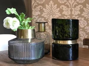 three vases sitting on a table with flowers in them at Perlépampille in Dinan