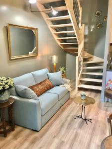 a living room with a couch and a staircase at Perlépampille in Dinan +19 photos