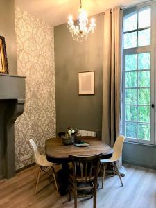 a dining room with a table and chairs and a chandelier at Perlépampille in Dinan