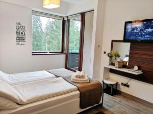a bedroom with a bed and a flat screen tv at The Evergreen Nest - Silver Mountain in Poiana Brasov