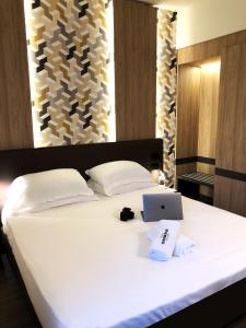 a bedroom with a bed with a laptop on it at Hotel Ombra in Riccione