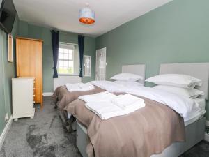 3 Betten in einem Zimmer mit grünen Wänden in der Unterkunft Hall Cottage in Richmond