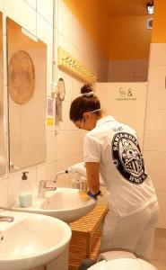 una mujer parada frente a un lavabo en un baño en Santander Central Hostel, en Santander