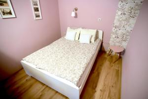 a small bedroom with a bed with white sheets and pillows at Studio Ulpia in Plovdiv