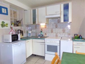 a kitchen with white appliances and a green table at Doubs Séjour - Maison de vacances in Verdun-sur-le-Doubs