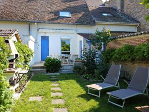 een kleine tuin met twee stoelen en een huis bij Doubs Séjour - Maison de vacances in Verdun-sur-le-Doubs