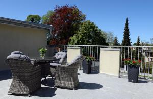 a patio with a table and chairs and a fence at Rezydencja Myśliwska - Apartamenty Biznes in Koszalin
