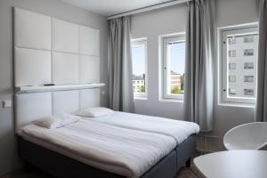 Un dormitorio con una cama grande con ventana. en Omena Hotel Vaasa Espen, en Vaasa