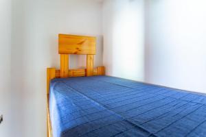 a bed with a blue comforter on top of it at Casa Dello Sciatore in Roccaraso