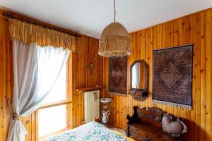 Schlafzimmer mit Holzwänden, einem Bett und einem Fenster in der Unterkunft Casa Dello Sciatore in Roccaraso