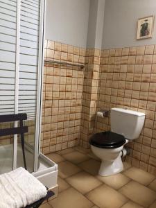 a bathroom with a toilet with a black seat at Belle de Nuit in Oppède