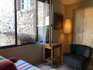 a room with a table and a chair and a window at Belle de Nuit in Oppède