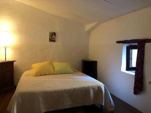 um quarto com uma cama com uma almofada amarela em Belle de Nuit em Oppède