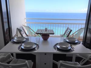 Una mesa con platos y servilletas y una vista al océano. en Seaside Apartment, en Sesimbra