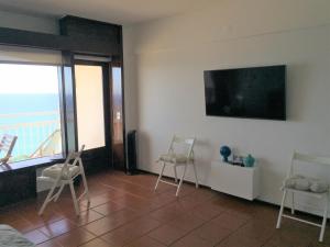 Una sala de estar con sillas y un televisor de pantalla plana. en Seaside Apartment, en Sesimbra