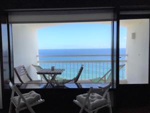 Una habitación con balcón con mesa y sillas. en Seaside Apartment, en Sesimbra